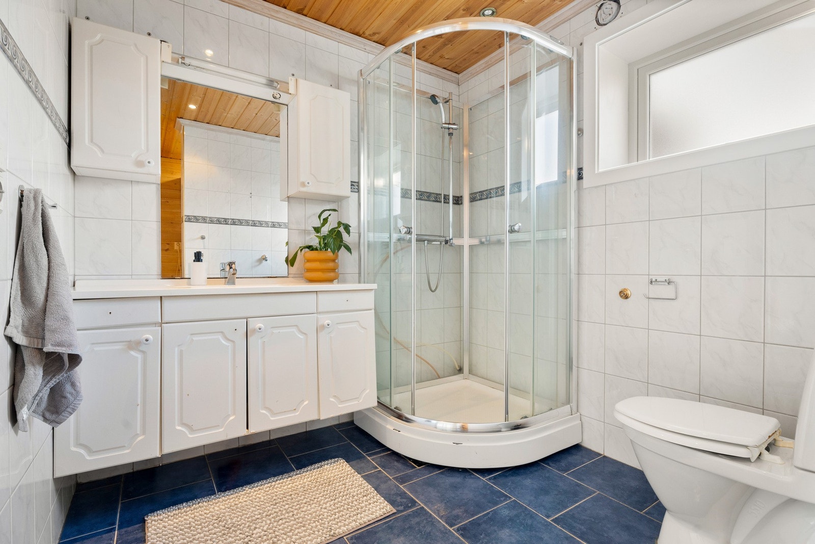 Badet har et toalett, et dusjkabinett, elektrisk håndkletørker, elektrisk gulvvarme og opplegg for vaskemaskin. Galleribilde