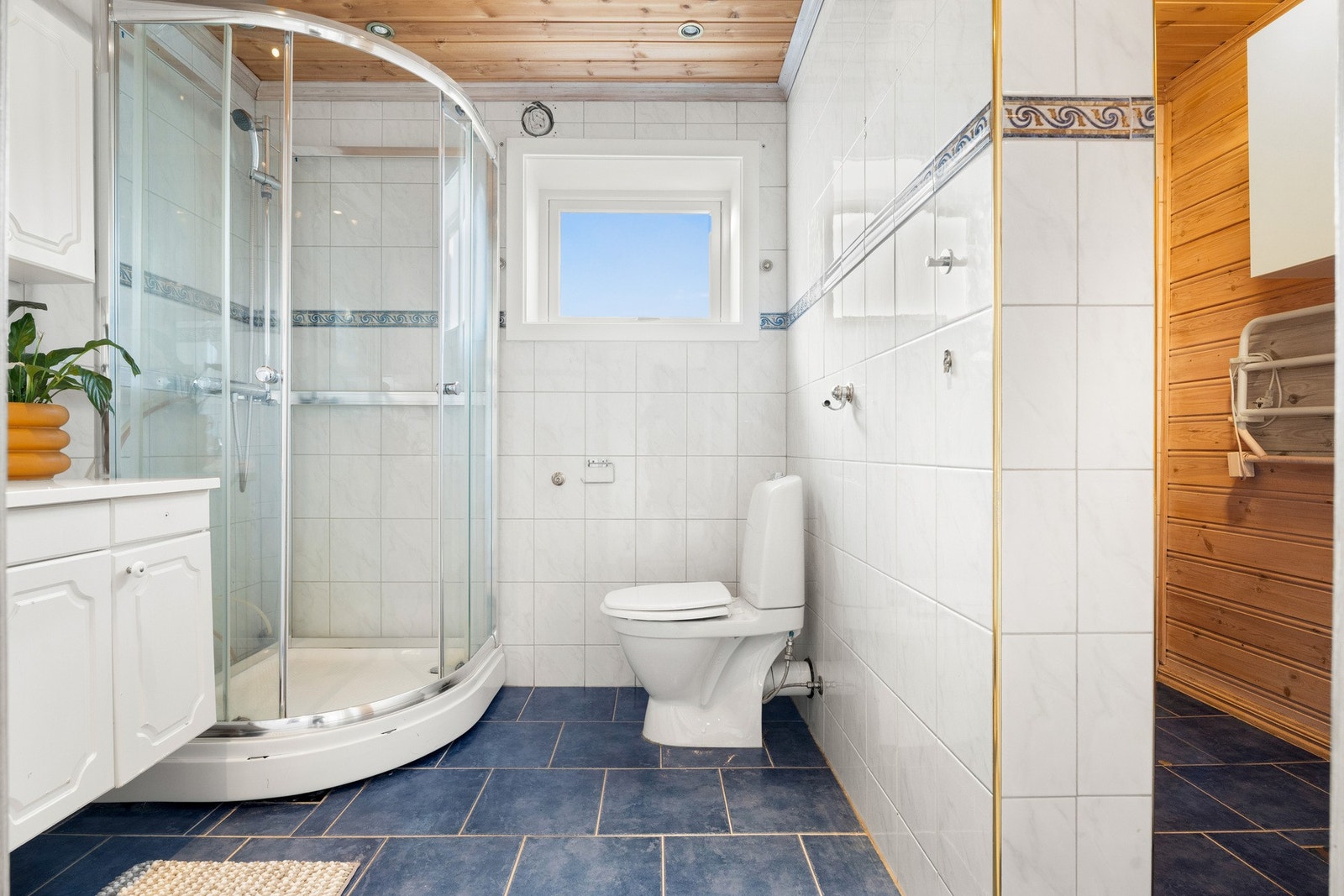 Baderomsinnredningen har hvite, profilerte fronter og består av en heldekkende servant på en skapseksjon, to veggskap og et speil med belysning. Galleribilde