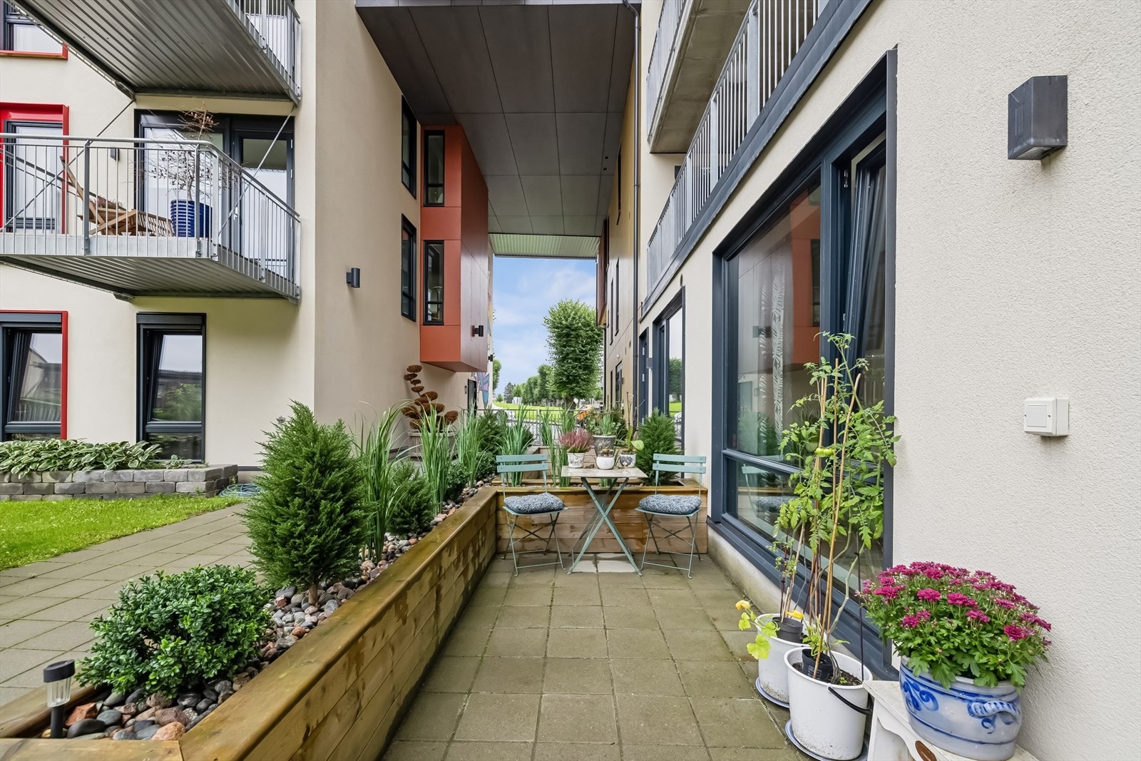 Utenfor inngangen har du en koselig uteplass som er fint rammet inn av beplantning. Galleribilde