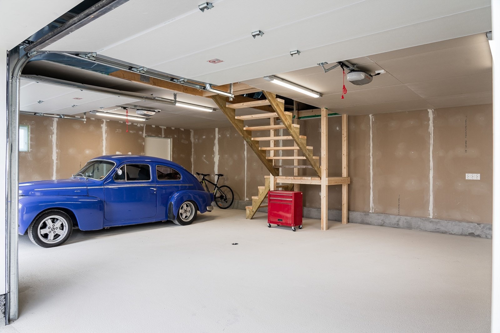 Inne i garasjen er det bygd en trapp slik at man har mulighet til å ta seg opp for å enklere kunne ferdigstille loftsplanet. Garasjen er utstyrt med varmekabler i betonggulvet, og det er plass for å sette opp f.eks. en arbeidsbenk. Galleribilde