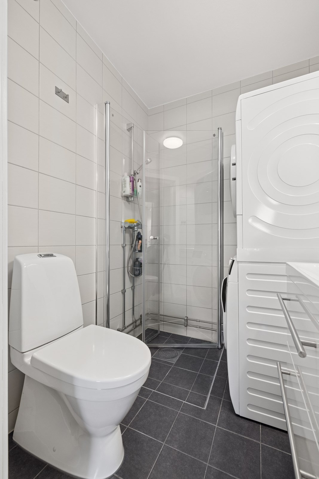 Badet er utstyrt med dusjhjørne, wc, opplegg for vaskemaskin/tørketrommel og en moderne baderomsinnredning. Galleribilde