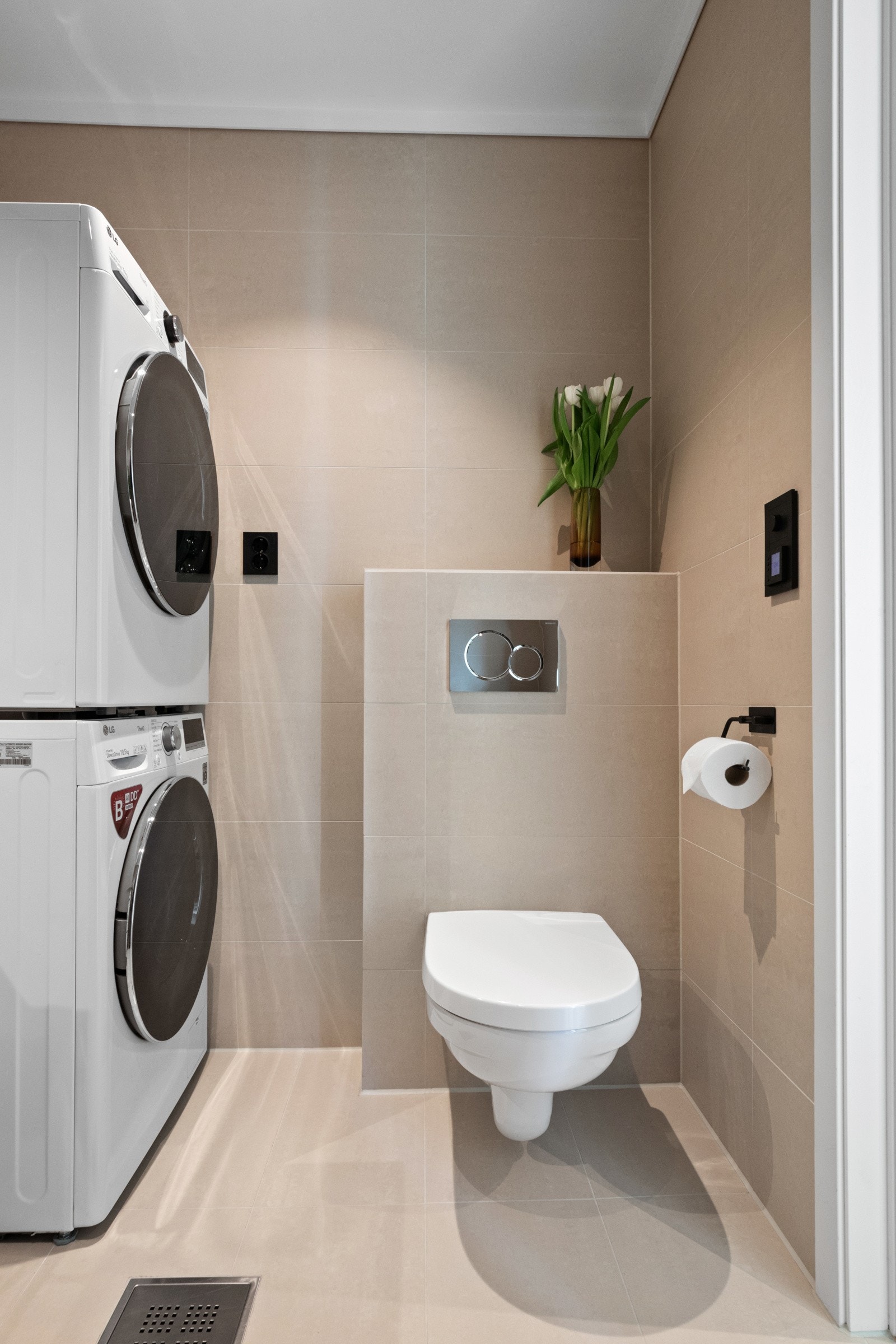 I tillegg til opplegg for vaskemaskin er rommet utstyrt med en hvit servantseksjon, et speil og et vegghengt toalett. Galleribilde