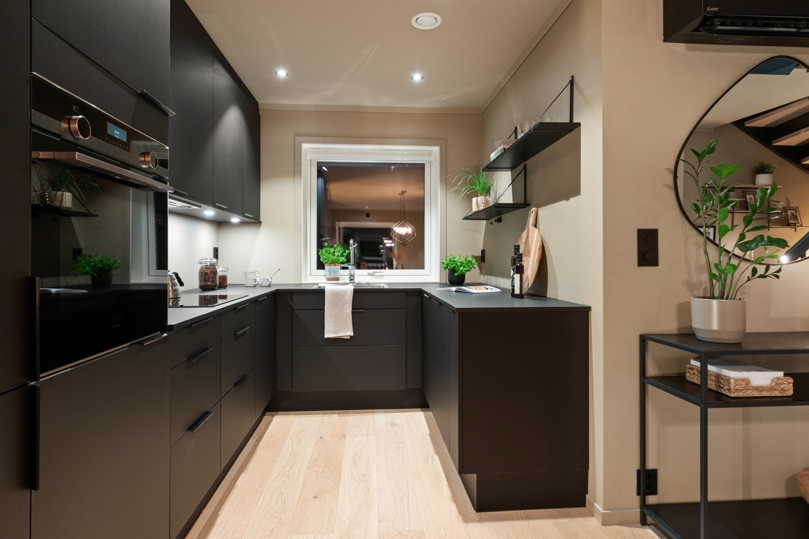 Videre er kjøkkenet utstyrt med integrerte hvitevarer som oppvaskmaskin, kjøl-/fryseskap, stekeovn og induksjonstopp, samt ventilator, benkestikk og god arbeidsbelysning. Galleribilde