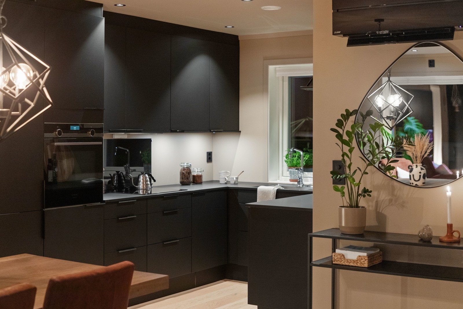 Innredningen har sorte, glatte fronter, takhøye skap og solid benkeplate i heltre med nedfelt kum i stål. Galleribilde