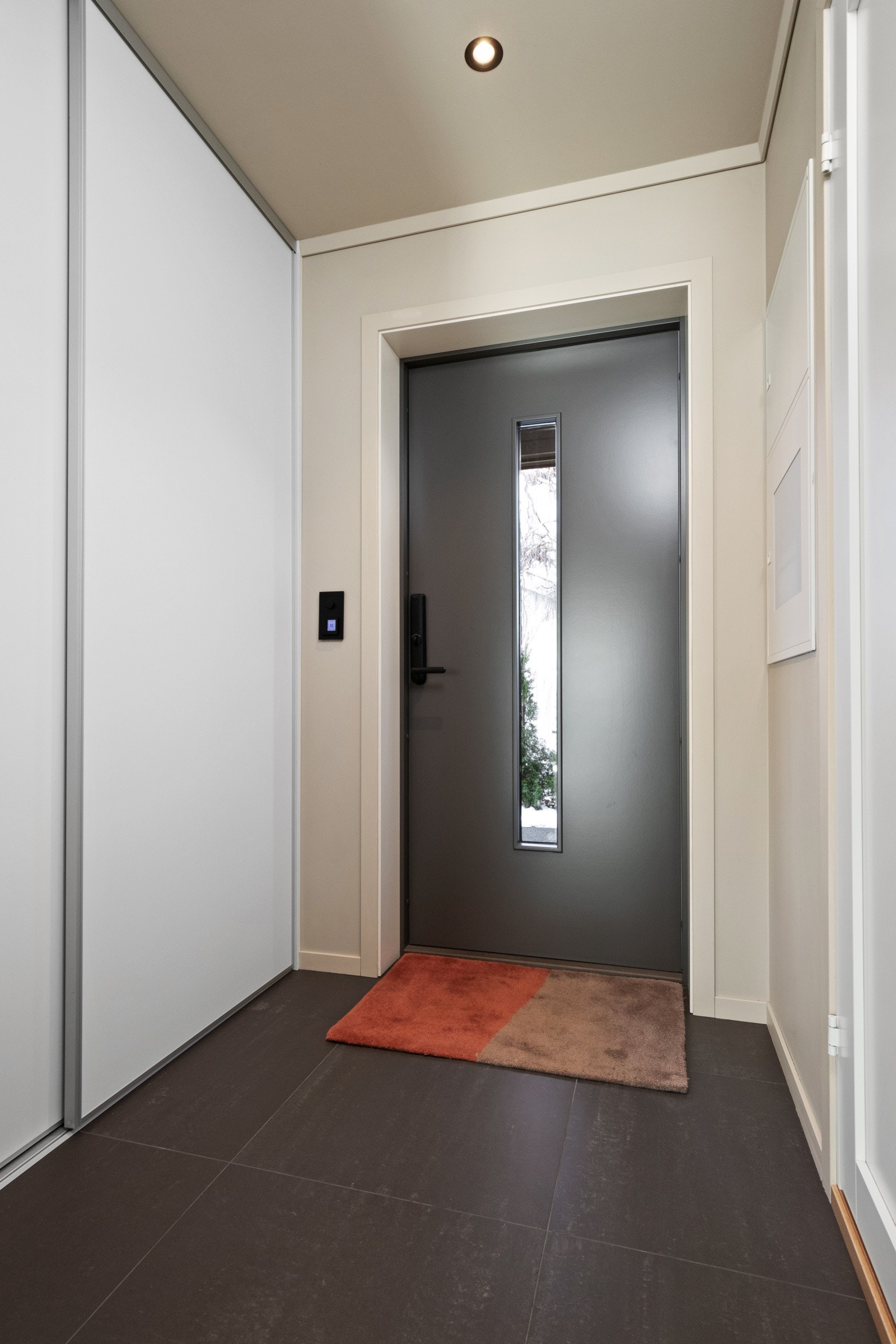Vel inne blir vi ønsket velkommen i en fin entré med lysmalte vegger, downlights i himlingen og grå fliser på gulv med gulvvarme. Galleribilde