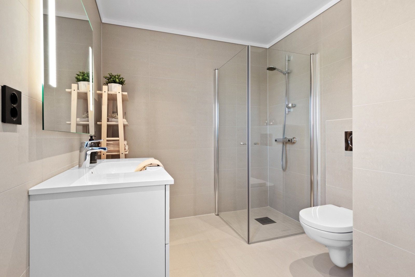 Badet ligger ved soverommene i andre etasje, og har store, lyse fliser på veggene og matchende fliser på gulv med gulvvarme. Galleribilde