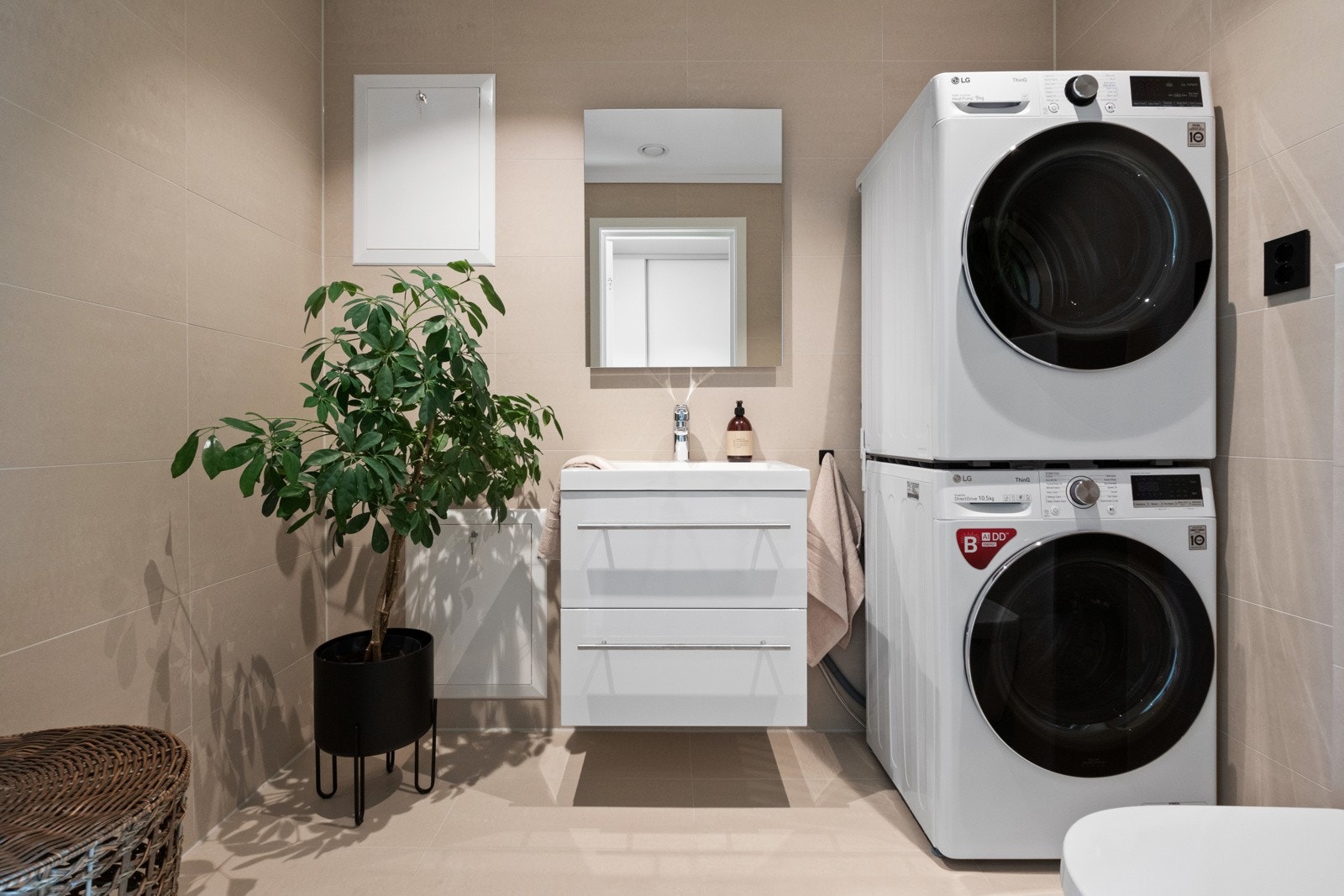 I hendig tilknytning til entreen er det et pent og praktisk vaskerom med lyse fliser på veggene og matchende fliser på gulv med gulvvarme. Galleribilde