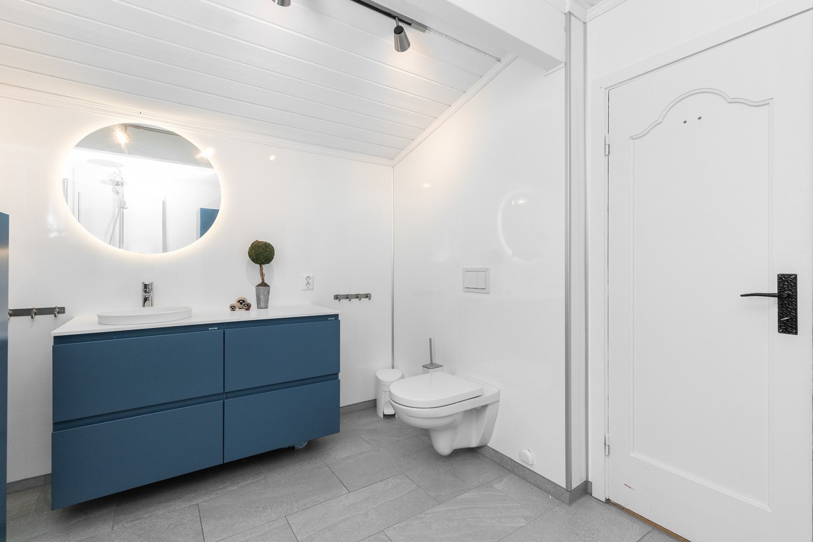 Badet har våtromsplater på vegger og flislagt gulv Galleribilde