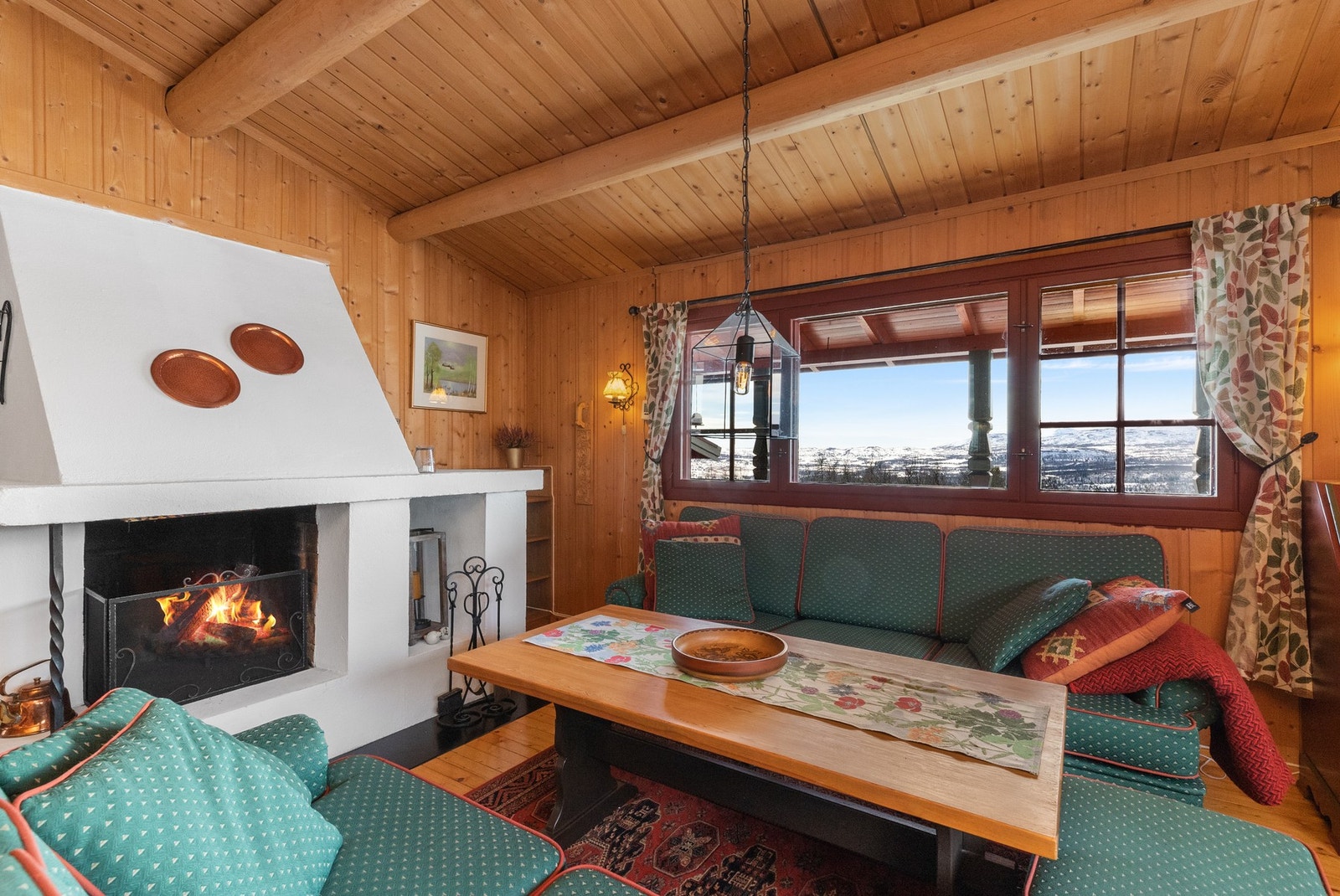 Stuen har gruepeis som bidrar til en hyggelig stemning til rommet Galleribilde