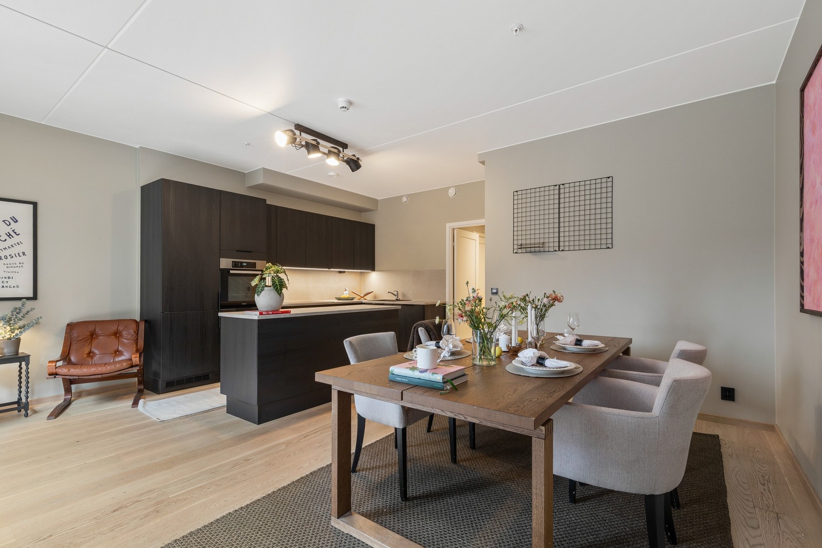 Den åpne løsningen mellom stue og kjøkken gir boligen en luftig følelse og skaper et naturlig samlingspunkt for sosiale sammenkomster Galleribilde