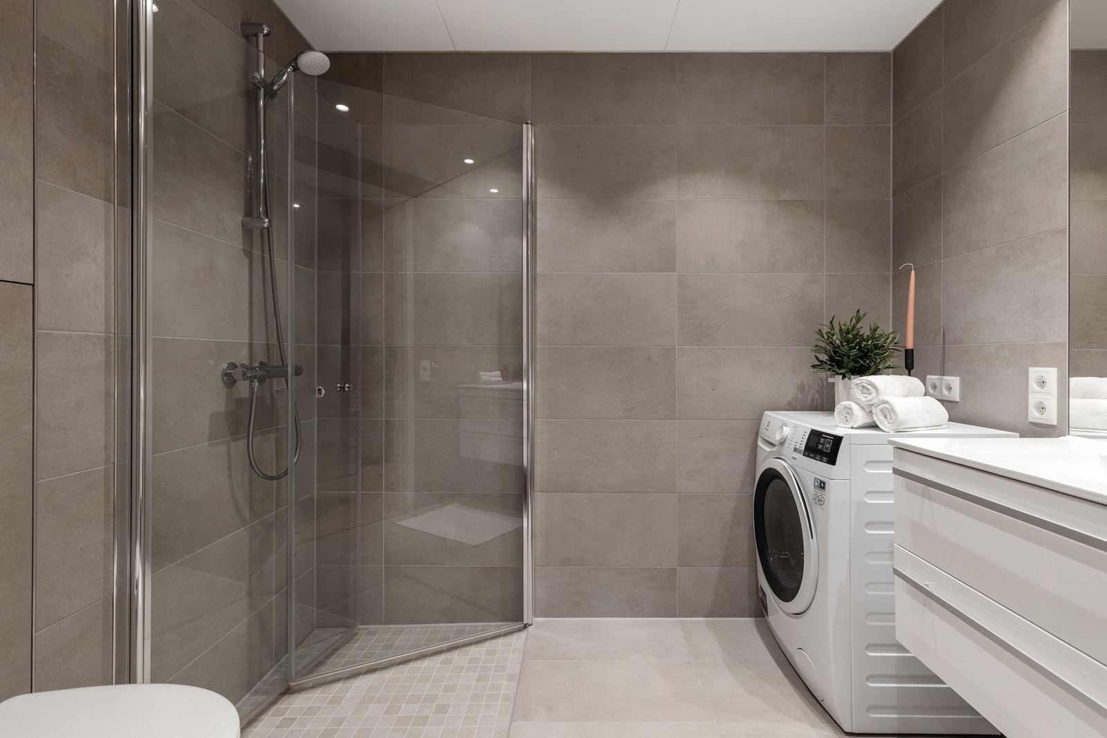 Delikat, helfliset bad med vannbåren gulvvarme og downlights i himling Galleribilde