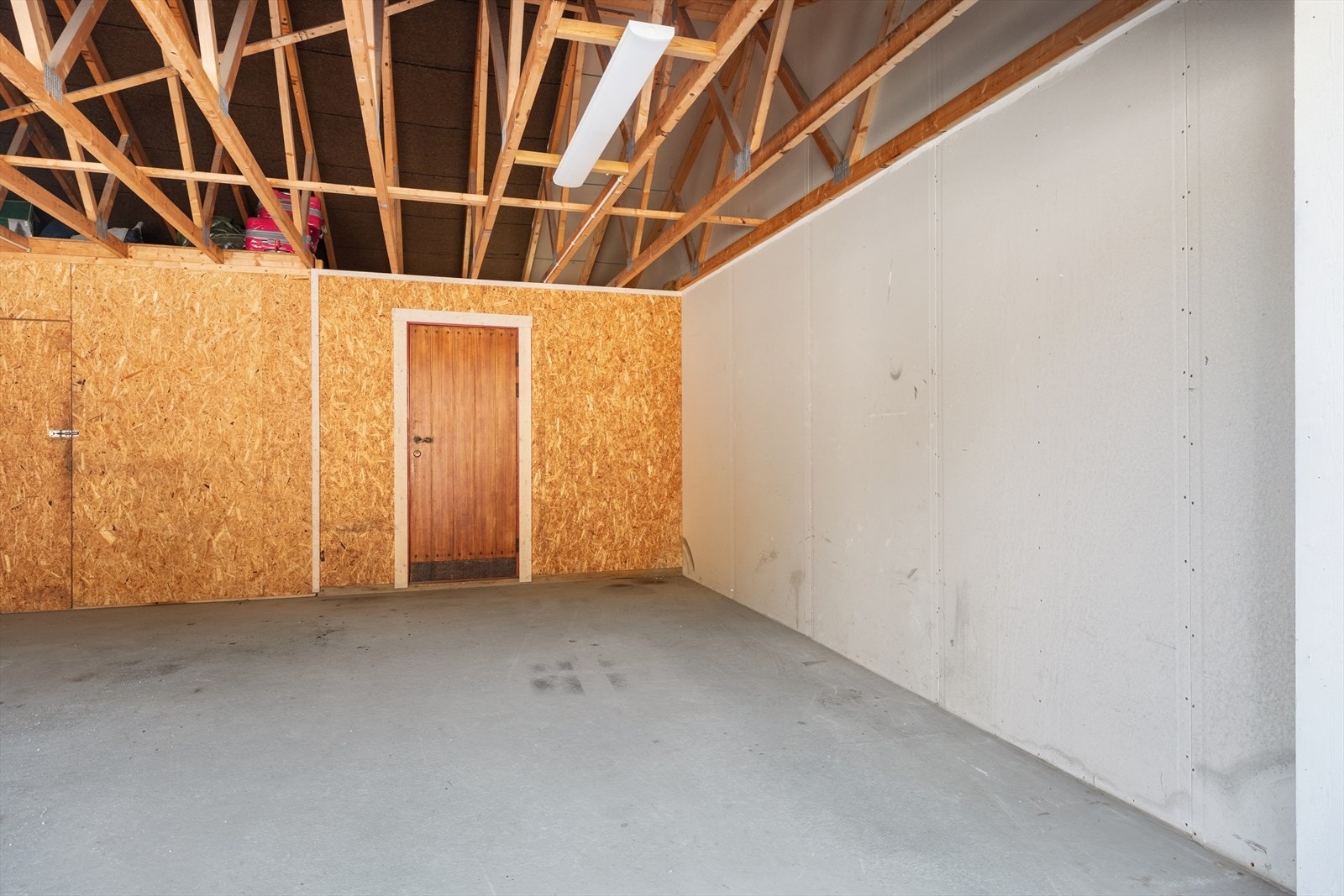 Carport med parkeringsplass til ein bil og praktisk bod i bakkant. Galleribilde