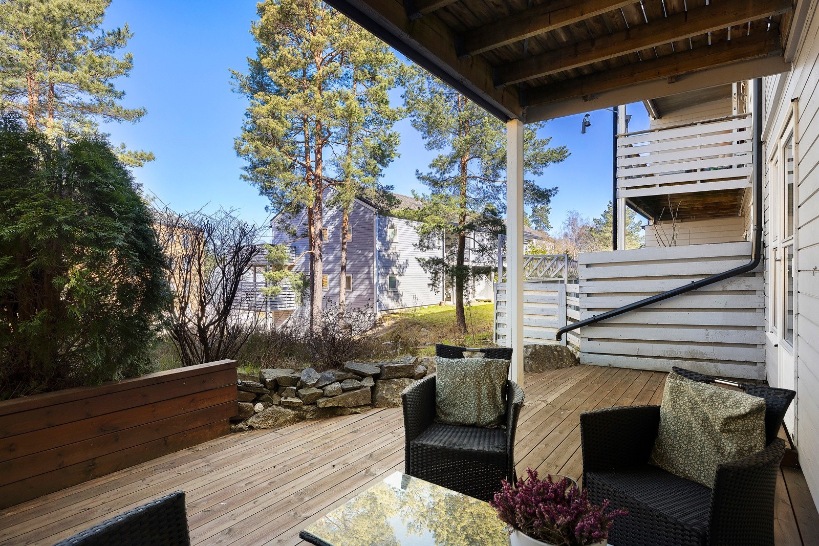 Terrassen nede er en lun plass med kveldsol, omgitt av naturen mellom lavblokkbebebyggelsen. Galleribilde