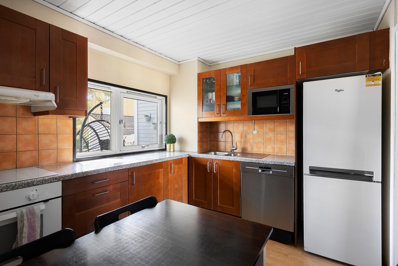 Kjøkken med integrerte hvitevarer, oppvaskmaskin, stekeovn og mikrobølgeovn. Store vinduer gir godt lysinnslipp. Galleribilde