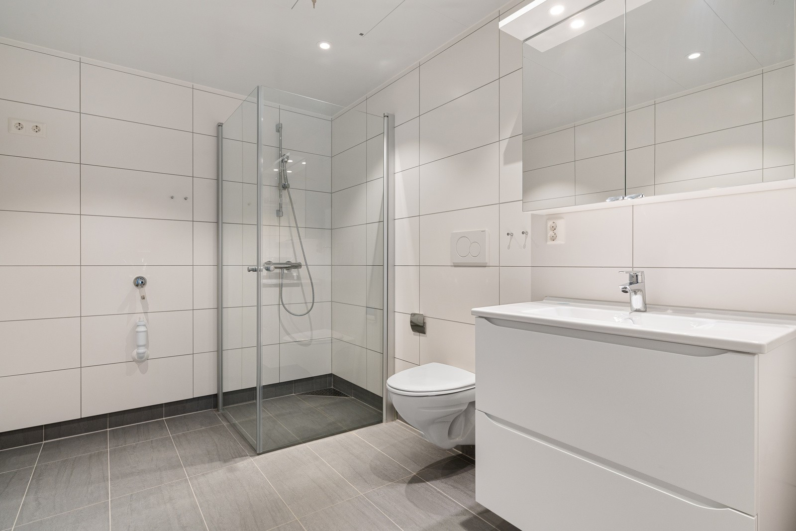 Pent flislagt baderom med downlights i himling og varme i gulv.