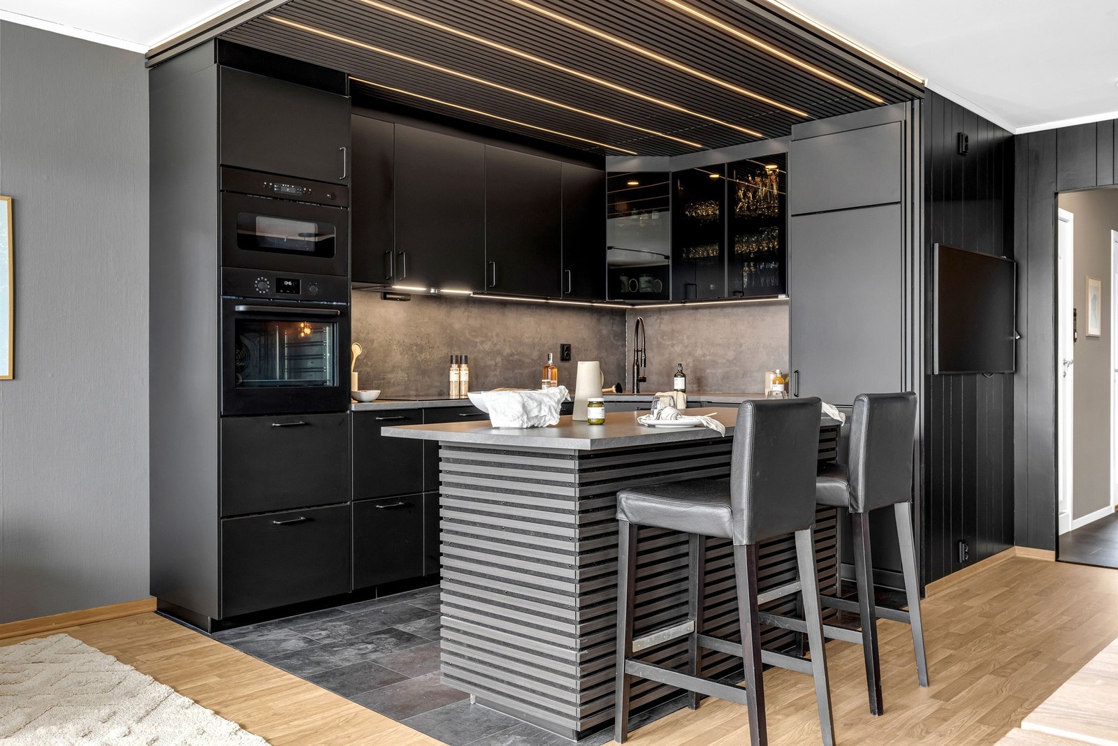 Kjøkkeninnredning med glatte fronter, benkeplate av laminat og nedsenket oppvaskkum med ett-greps armatur. Galleribilde