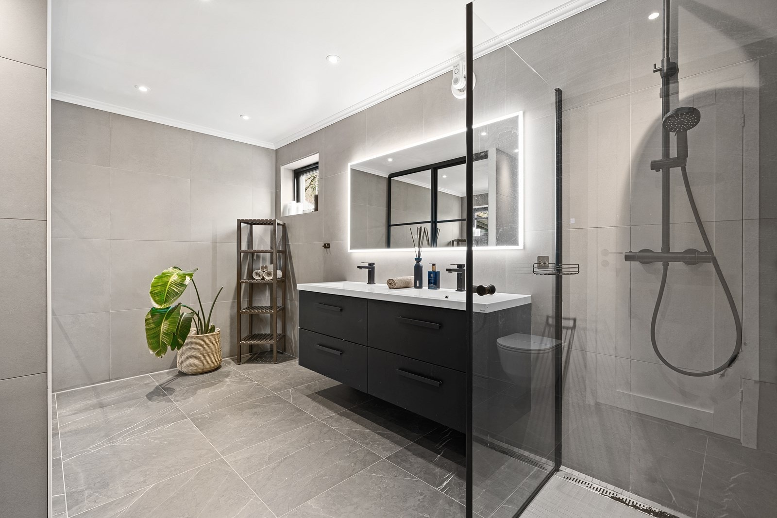 Badet er av meget god størrelse og lekkert oppgradert med store 60x60 fliser på gulv og vegger, samt at det er lagt mosaikkfliser på gulvet i dusjsonen. Galleribilde