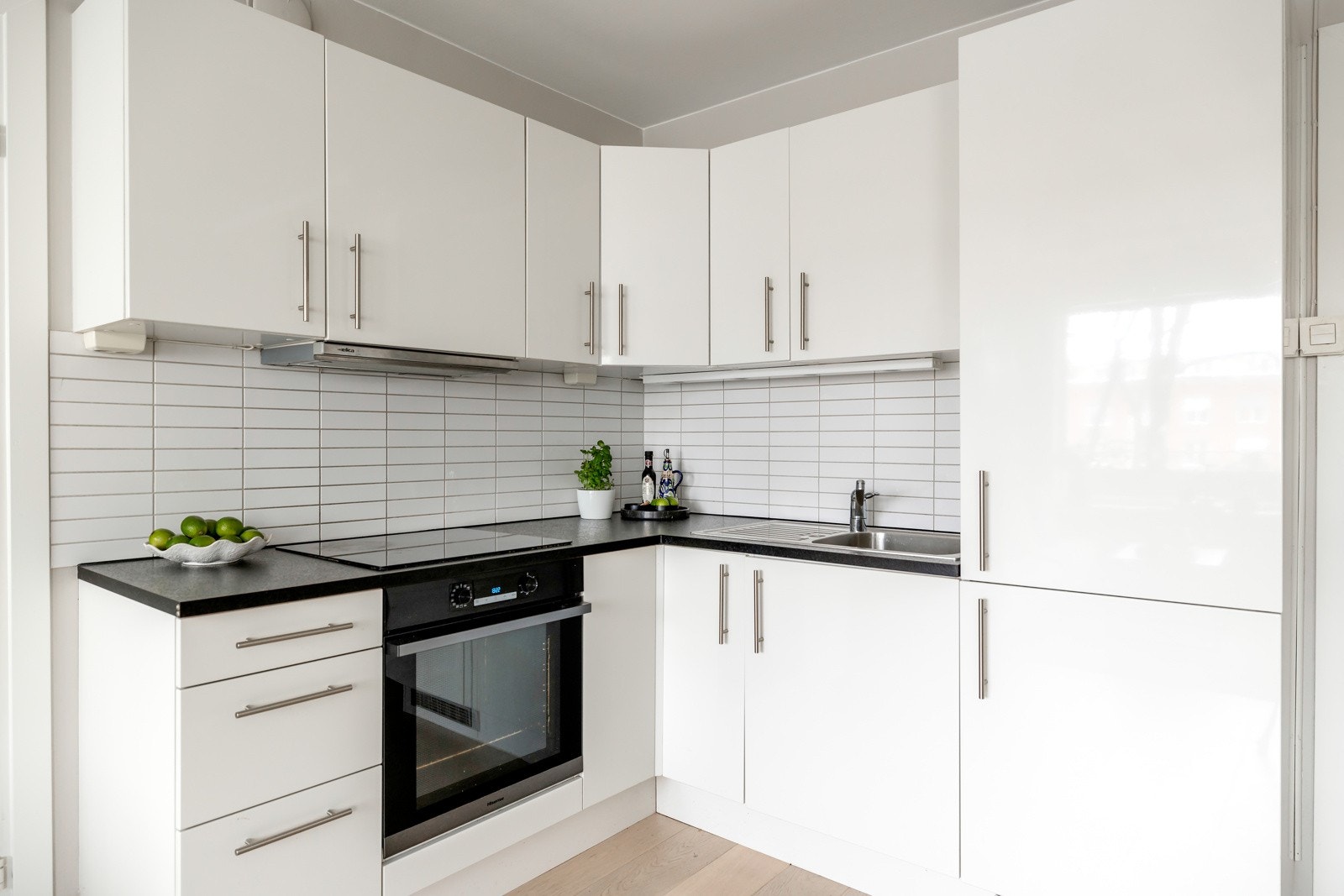 Kjøkkeninnredningen har glatte hvite fronter og laminat benkeplate Galleribilde