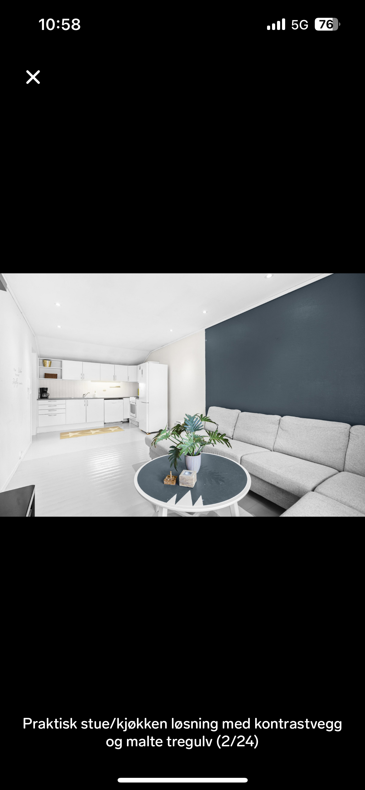 Praktisk stue/kjøkkenløsning med kontrastvegg og malte tregulv Galleribilde