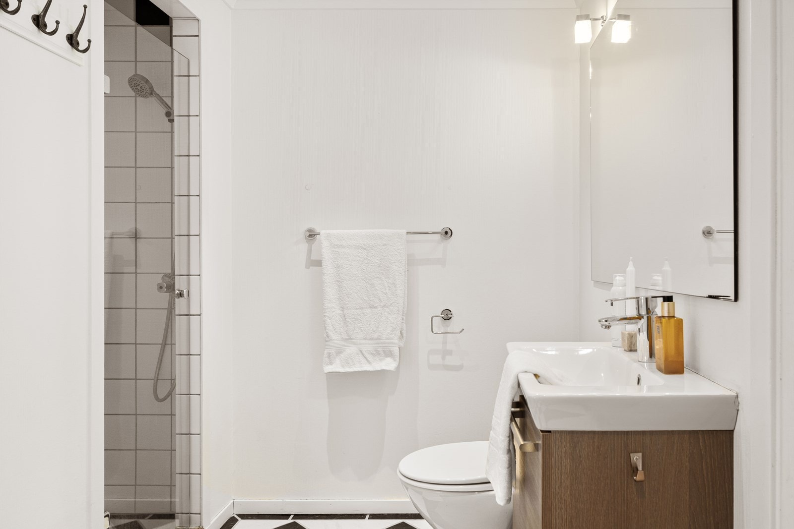 Badet er innredet med toalett, vask i seksjon, dusjnisje og speil. Galleribilde