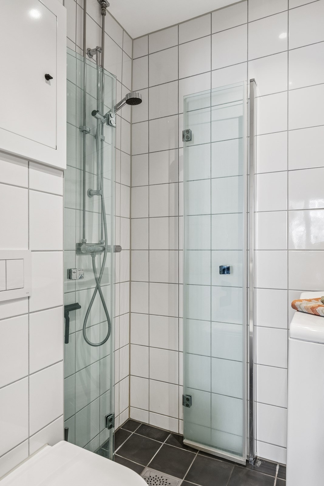 Badet er utstyrt med dusj med innfellbare dusjvegger og opplegg for vaskemaskin Galleribilde