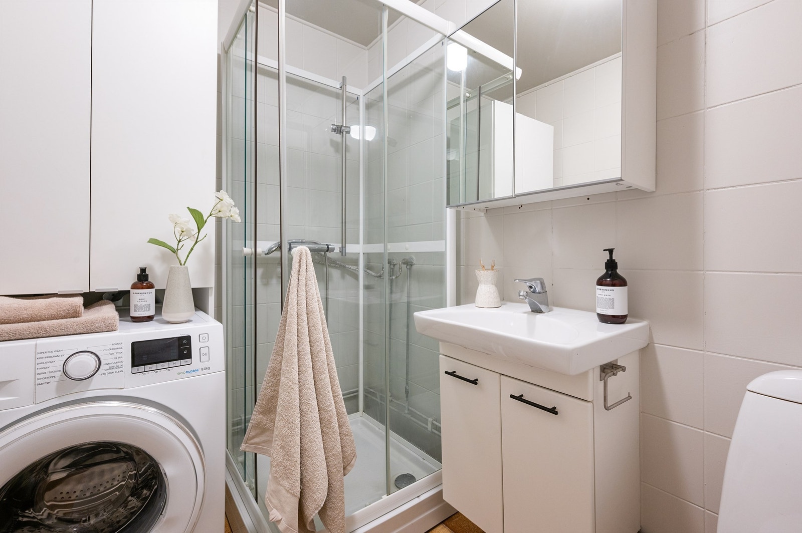 Badet har dusjkabinett og opplegg for vaskemaskin Galleribilde