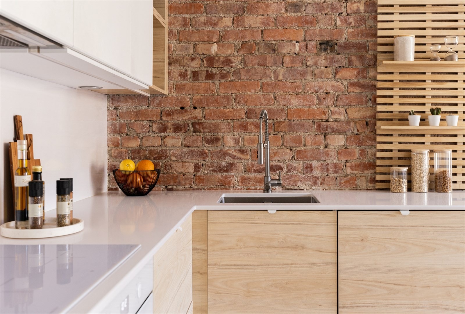 Over kjøkkenbenken har man en stilfull teglstein vegg som skaper et pent spill i rommet. Galleribilde