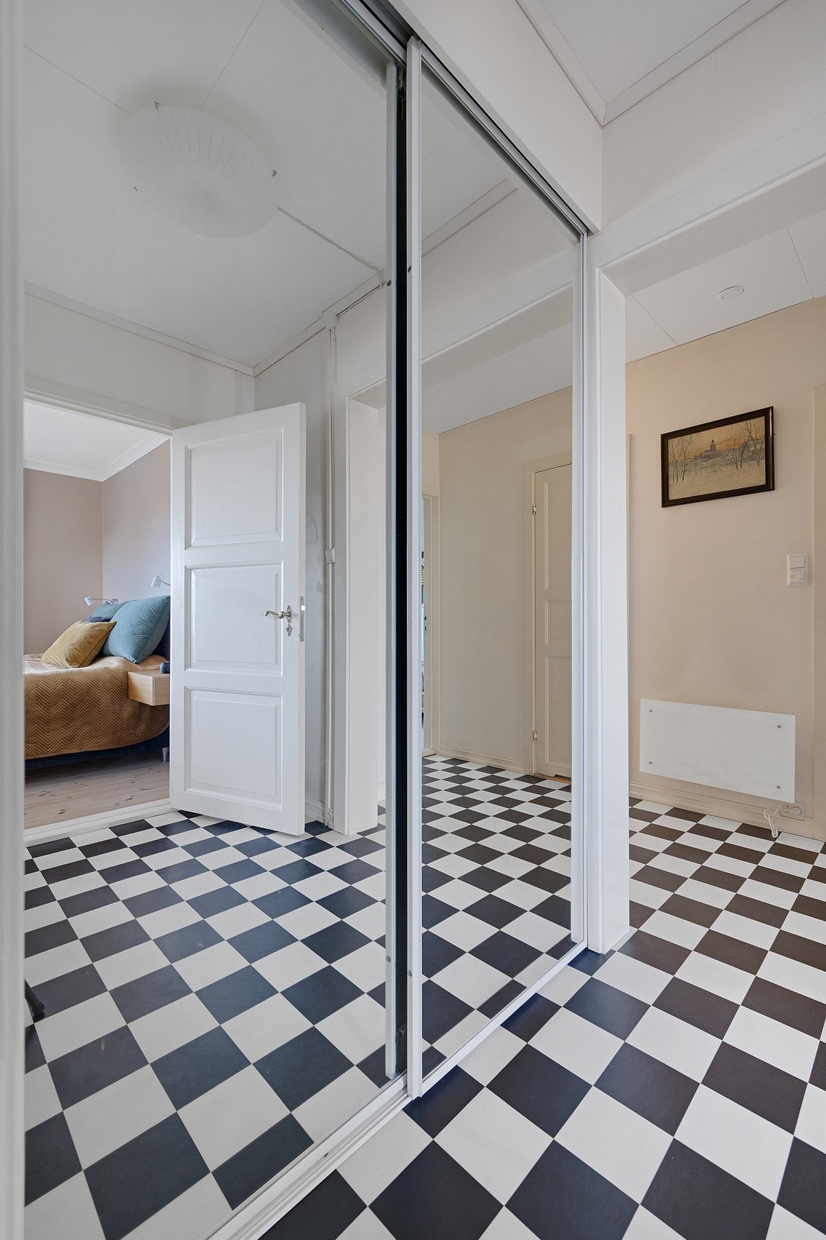 I hallen er det stor skyvedørsgarderobe med speil - vi ser litt av hovedsoverommet i speilet Galleribilde