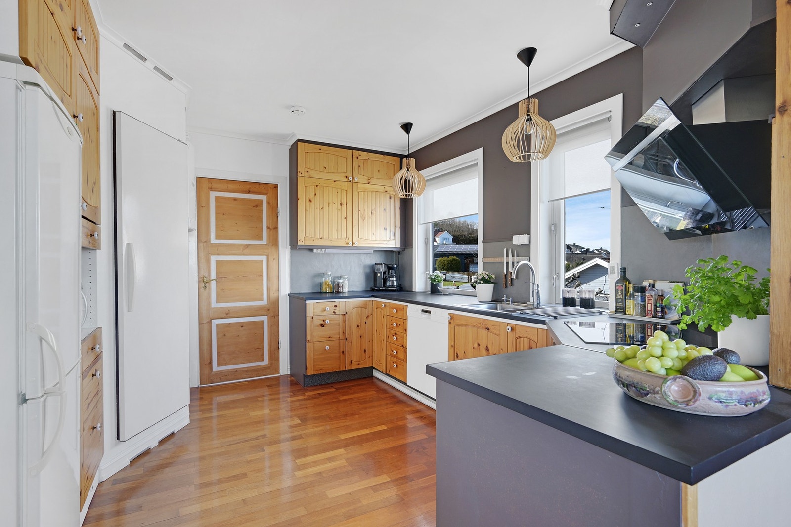 Fra kjøkkenet er det dør ut til gangen og vinduer med kveldslys Galleribilde