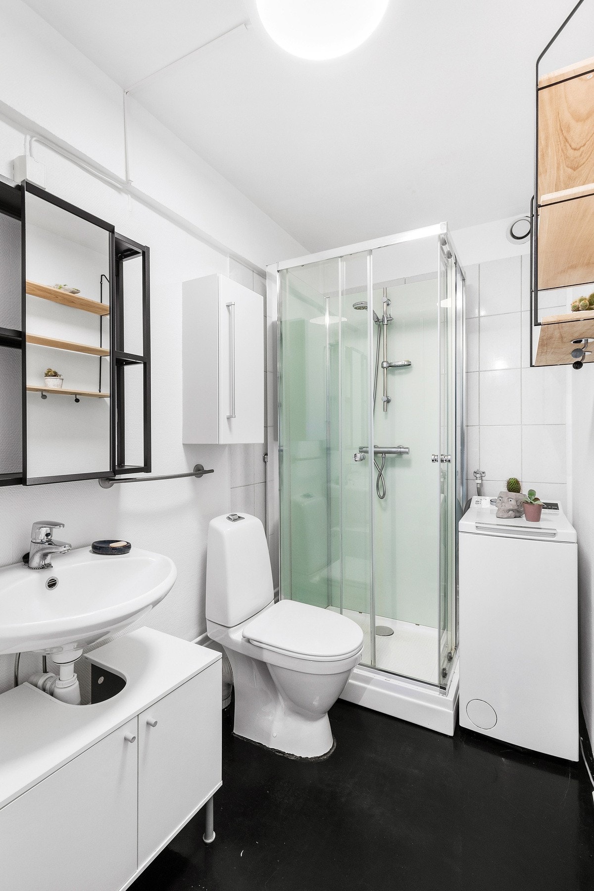 Baderom utstyrt med servant, servantskap, mekanisk avtrekk, opplegg for vaskemaskin, wc og dusjkabinett. Galleribilde