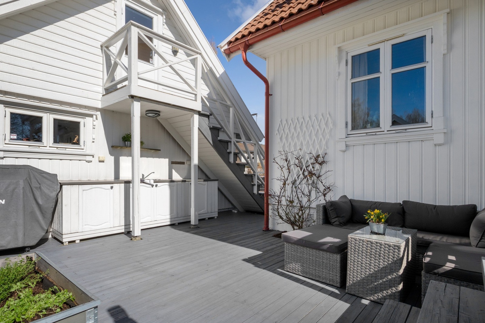 Inn mot garasjeveggen er det etablert utekjøkken. Kjøkkenet har varmt vann (liten varmtvannstank i benk) og egen plass for grill med gassflaske i skap ved siden av. Galleribilde