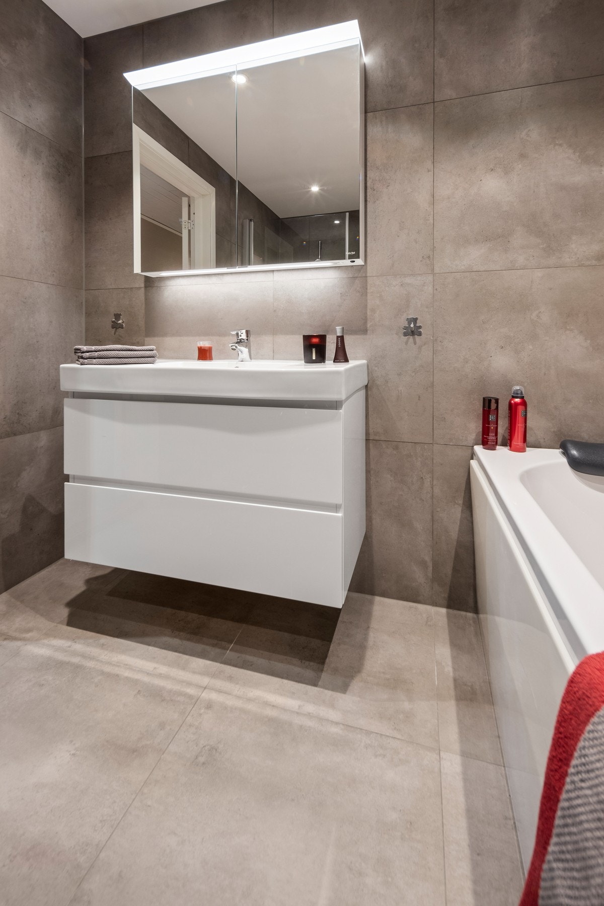 Innredningen er bestående av servant med underskap og speilskap, dusjhjørne med innfellbare glassdører i herdet glass, samt vegghengt toalett. Galleribilde