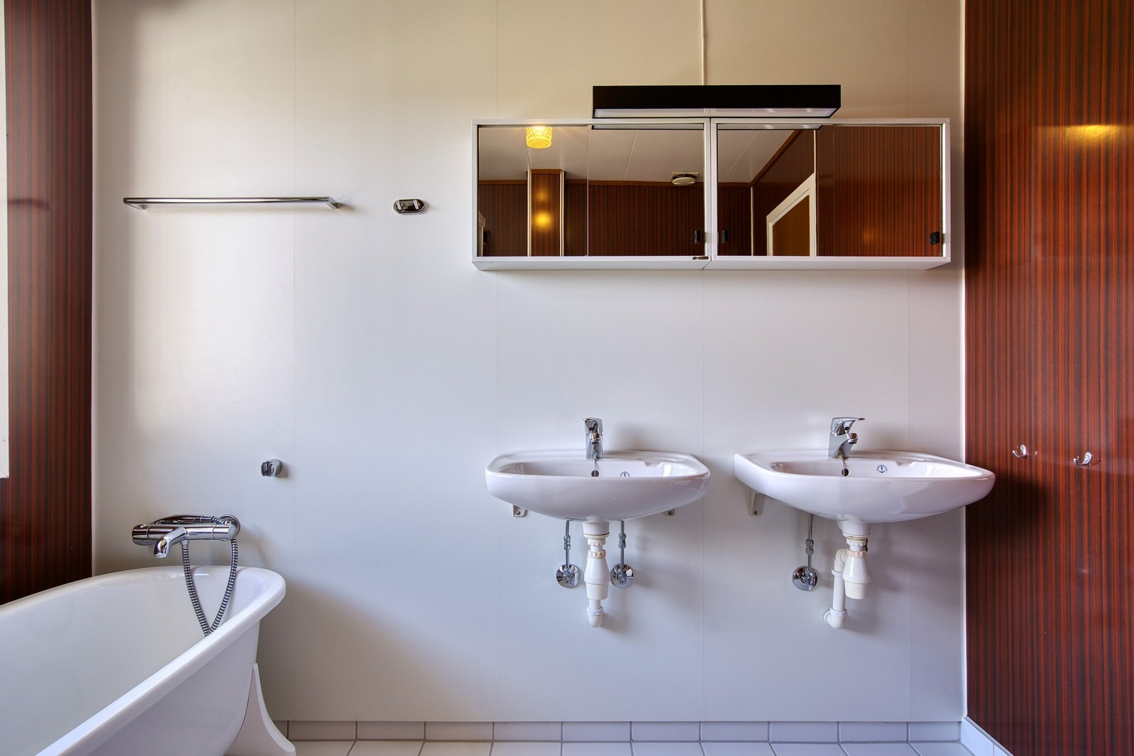 Badet er utstyrt med badekar, dusjkabinett, dobbelt servant og wc Galleribilde