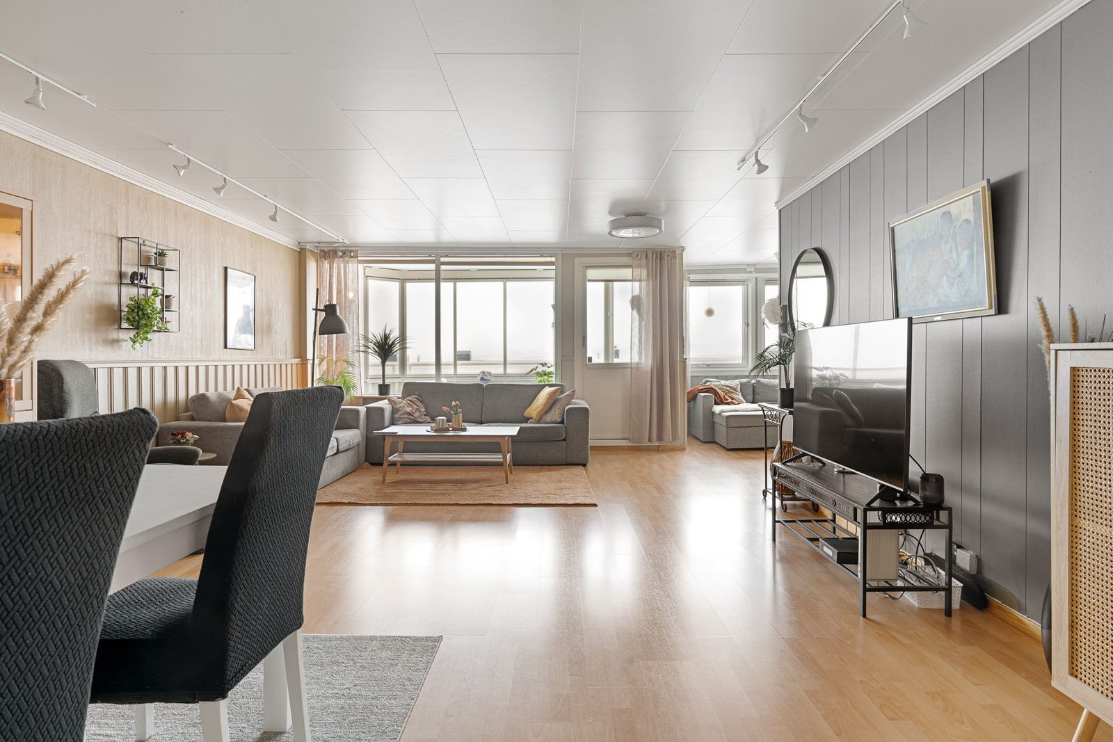 Stuen fremstår romslig med store vindusflater og naturlige soner for innredning av sofagruppe og spisebord.