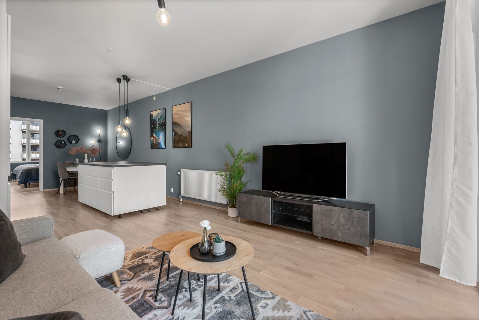 Stuen er samlingsplassen i leiligheten, et sosialt familierom med spiseplass, sofakrok og kjøkken i ett Galleribilde