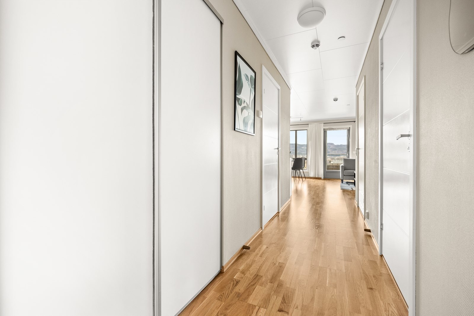 Velkommen inn i lys entré med god oppbevaringsplass i skyvedørsgarderobe Galleribilde
