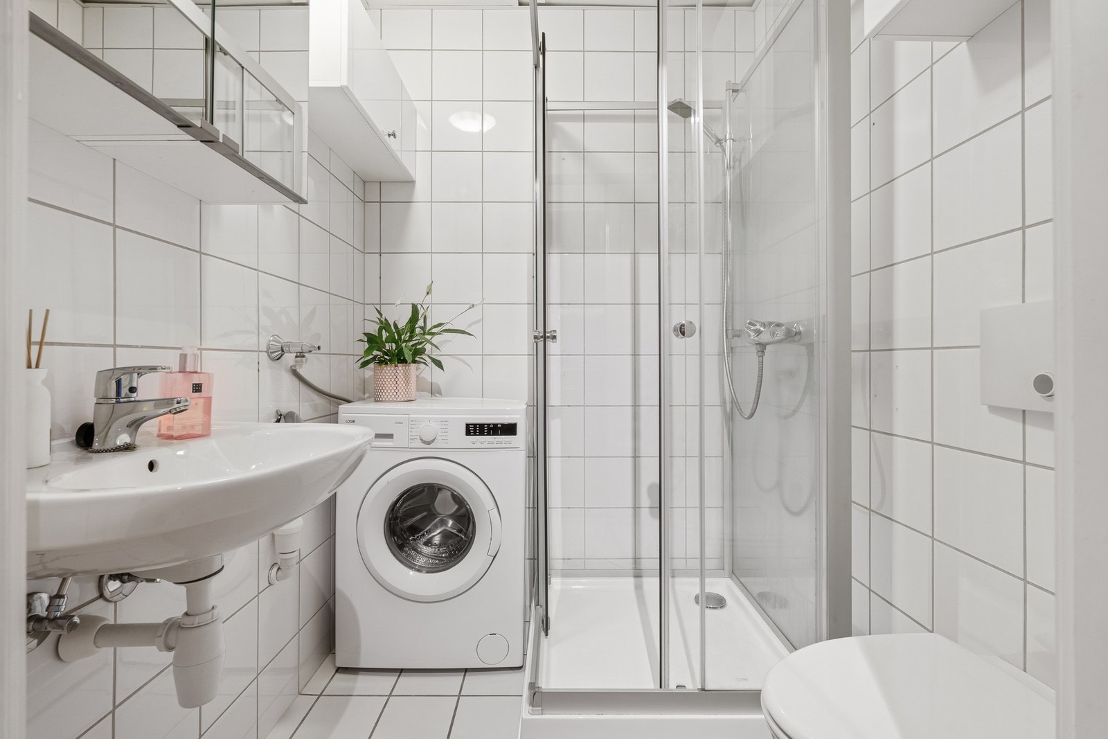 Hvitt flislagt bad fra byggeår (2004) med opplegg til vaskemaskin. Galleribilde