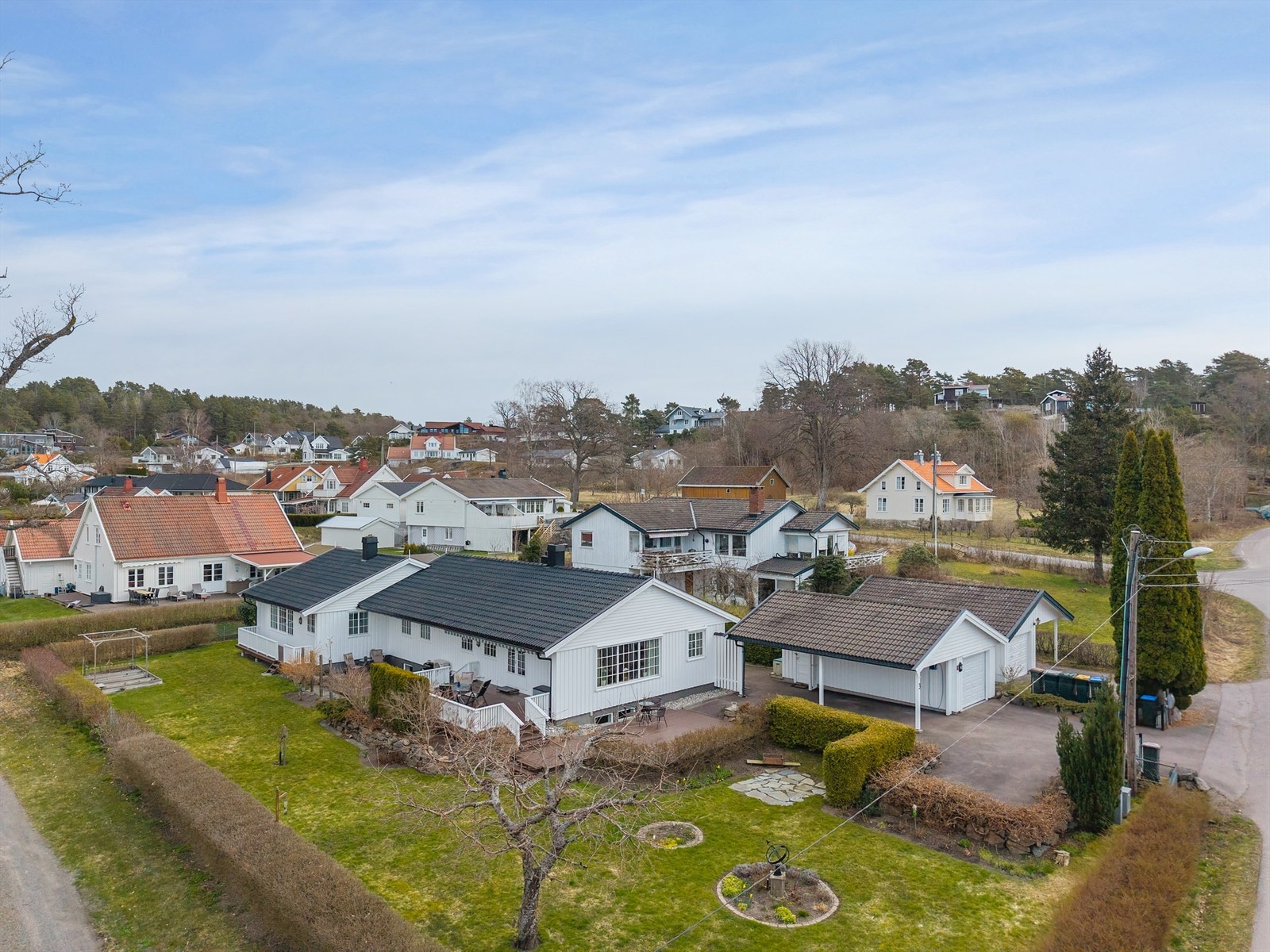 Tomten er relativt flat og er opparbeidet med gressplen, trær og pen beplantning. Det er plantet hekk rundt store deler av tomten som gir en mer skjermet følelse. Galleribilde