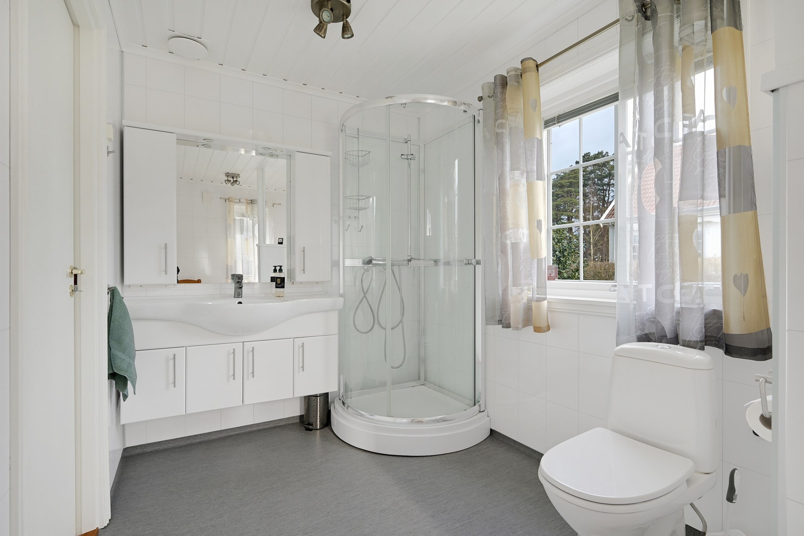 Badet er innredet med servant, dusjkabinett og toalett. Galleribilde