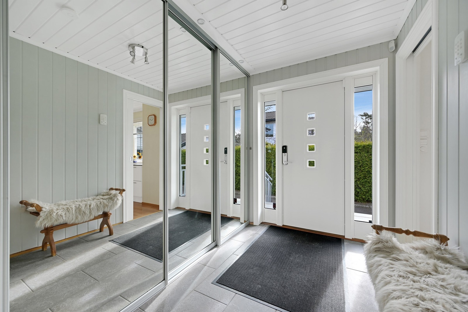 Lys entré med romslig skyvedørsgarderobe med speildører. Galleribilde