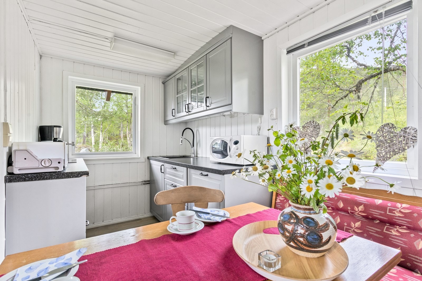 Kjøkkenet er utstyrt med servant, induksjonsplatetopp og kjøleskap. Galleribilde