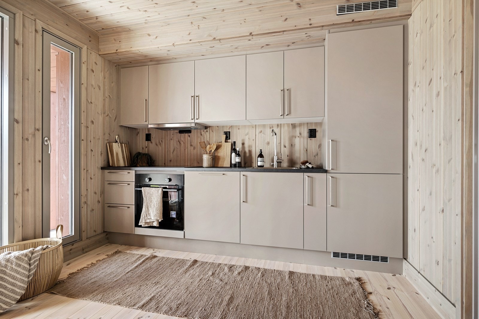 Kjøkkenet har en pen innredning fra HTH med glatte fronter, laminert benkeplate og integrert oppvaskmaskin, komfyr, platetopp og kombinert kjøl/frys. Galleribilde