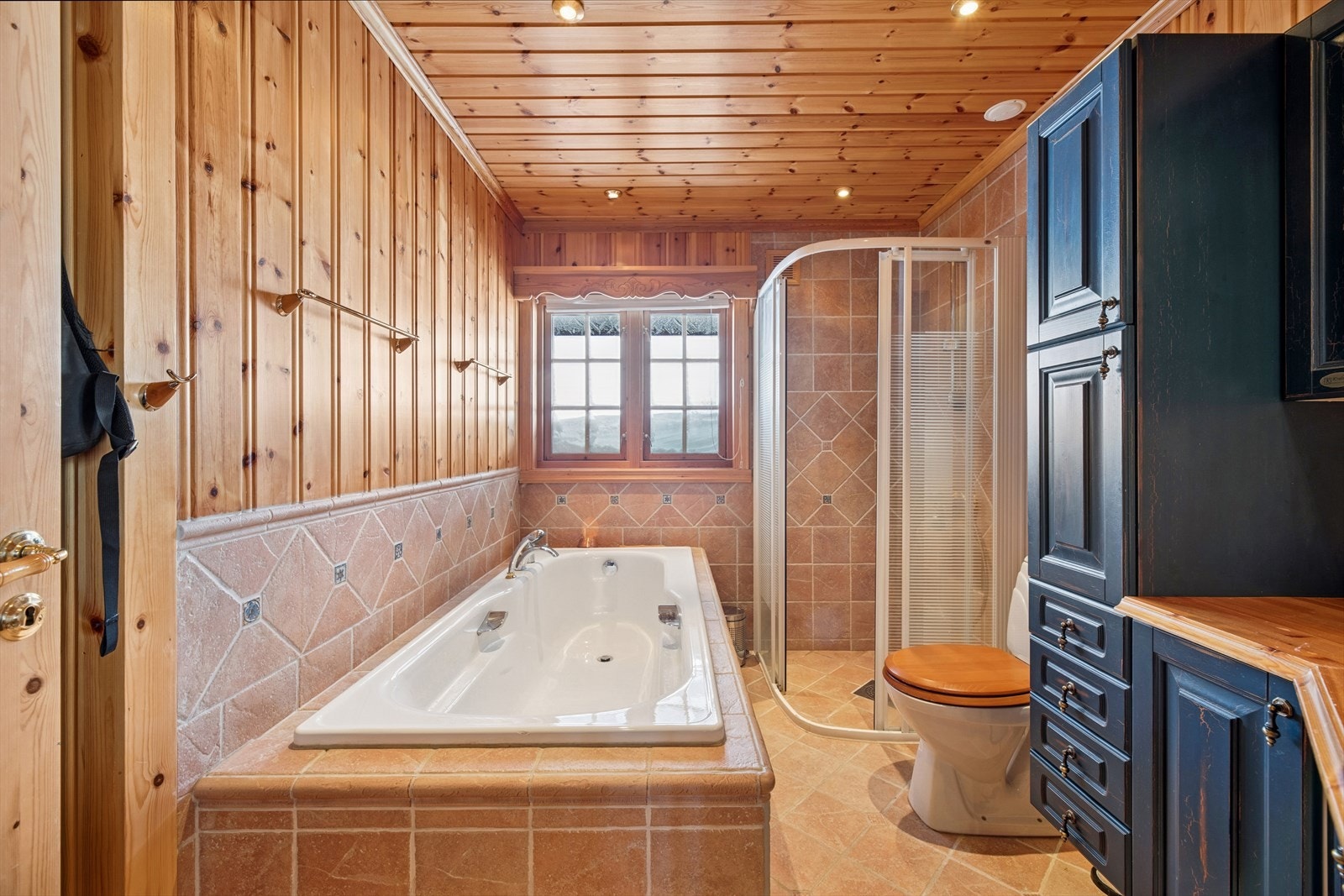 Badet er utstyrt med nedfelt servant, toalett, badekar og dusjvegger/hjørne. Galleribilde