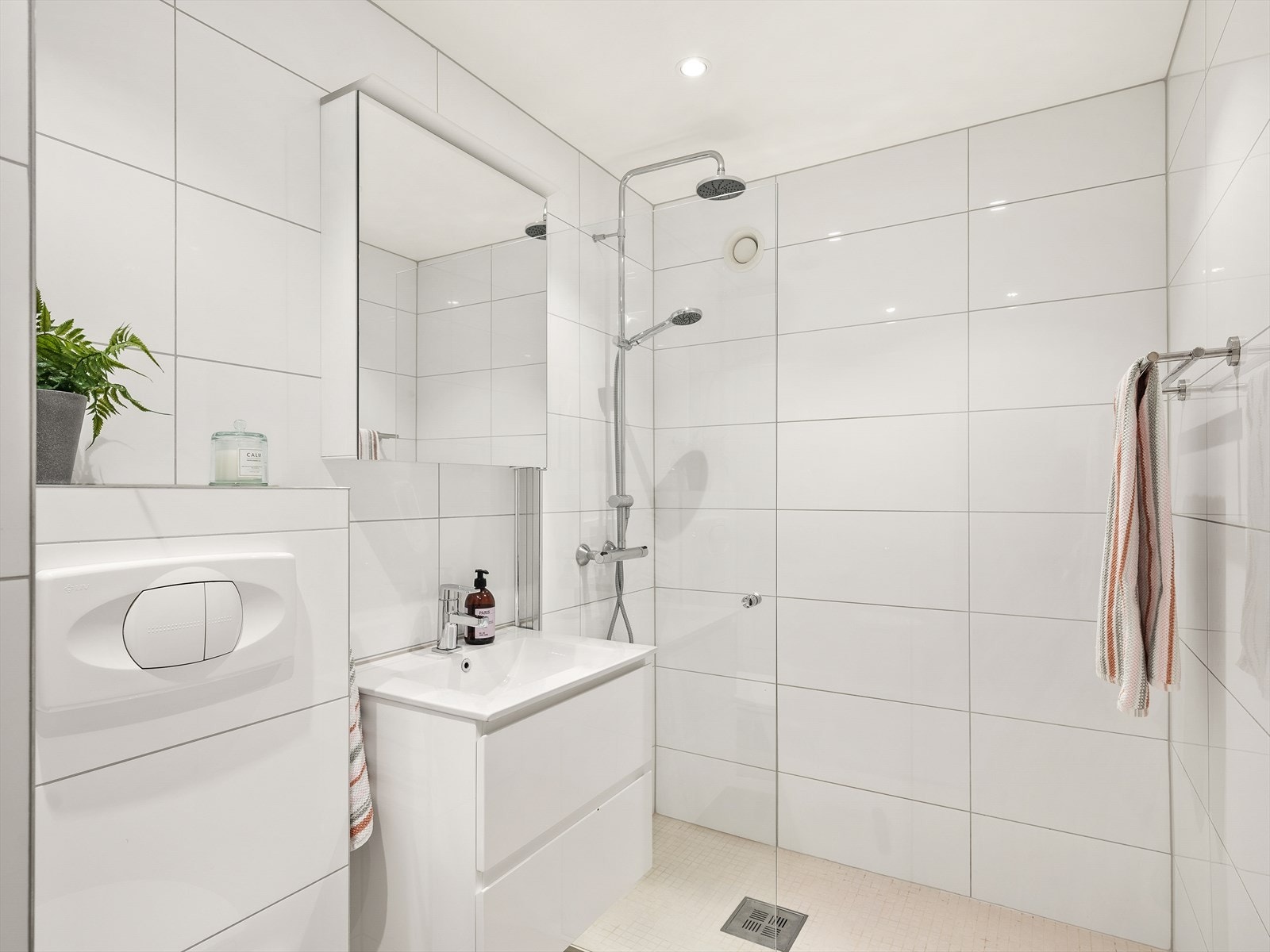 Badet er innredet med nedfelt servant, vegghengt toalett og en dusjvegg av glass. Galleribilde