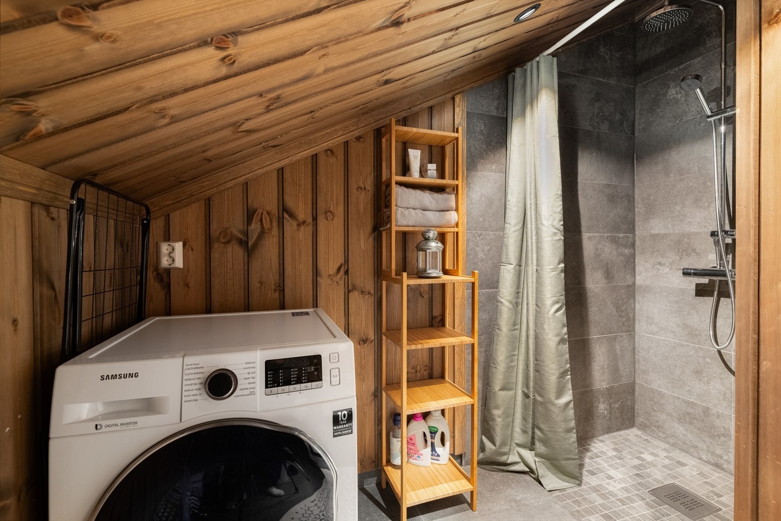 Baderom med fliser på gulv og i dusjsone, og varme i gulv. Ellers er det panel på vegger og i tak. Galleribilde