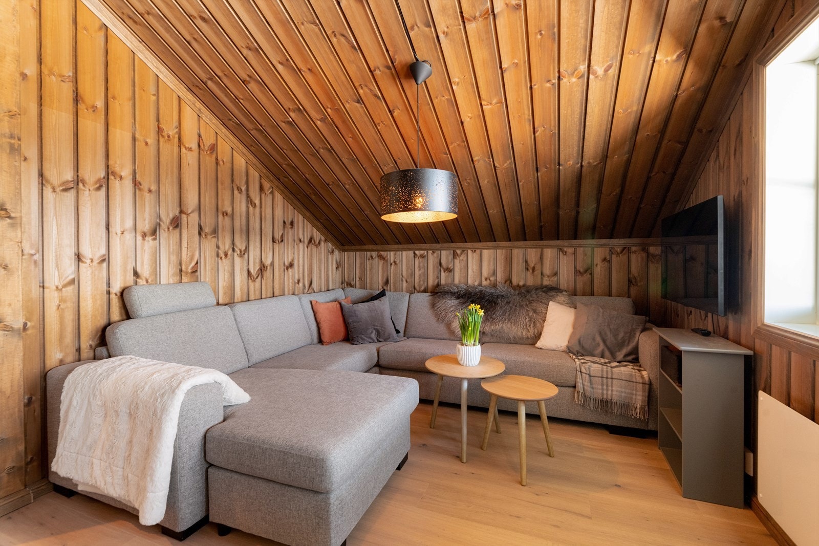 Lun og hyggelig loftstue/soverom med plass for sofa og mediemøbelment. Galleribilde