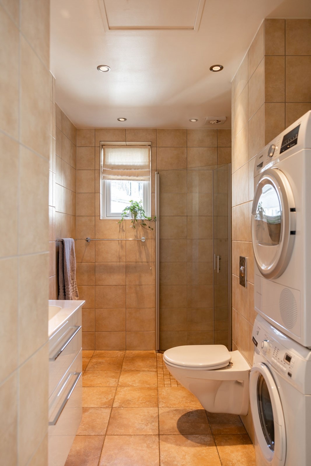 Flislagt baderom med varmekabler i gulvene og downlights i himlingen Galleribilde