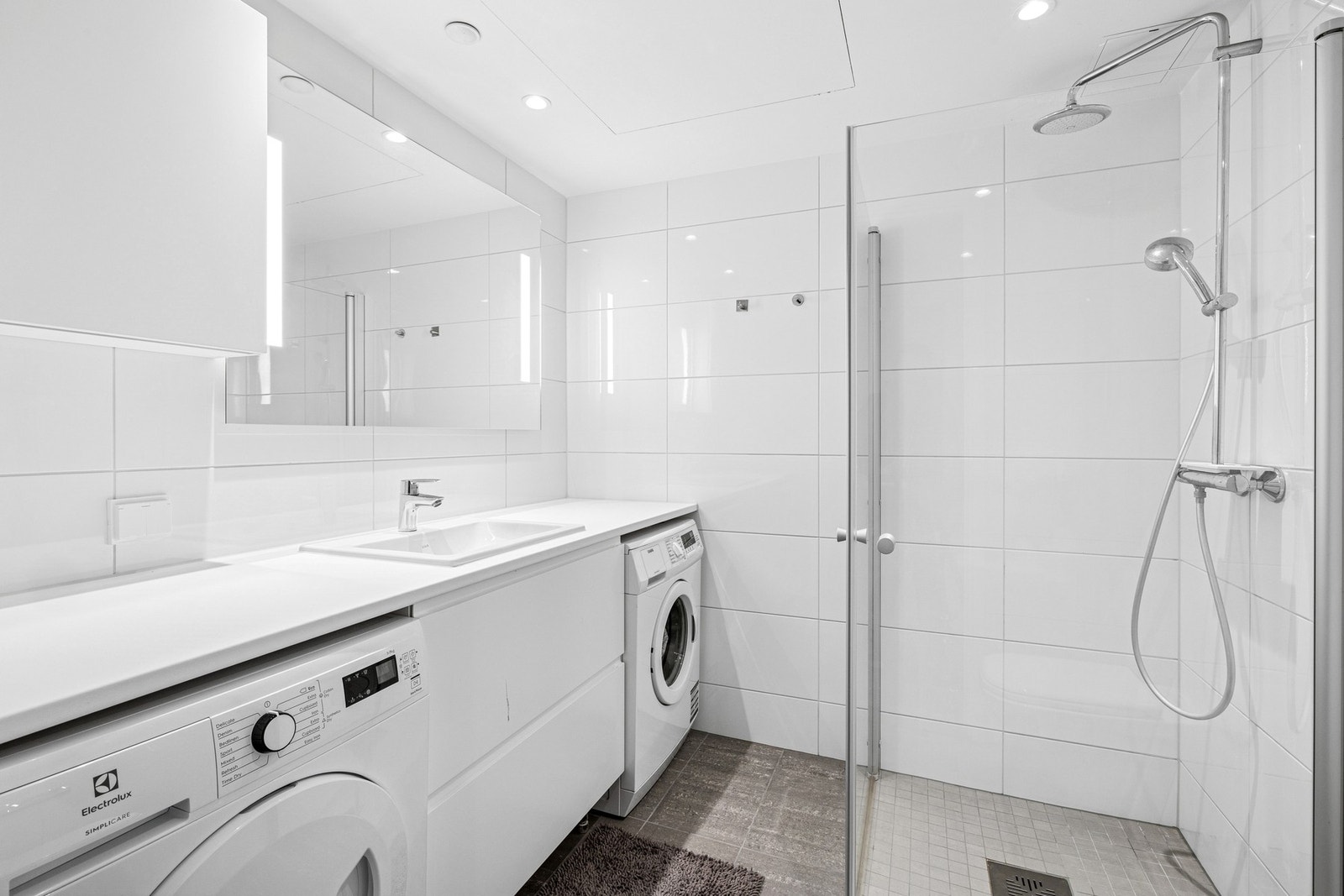 Badet har fliser på gulv og vegg. Opplegg for vaskemaskin. Galleribilde