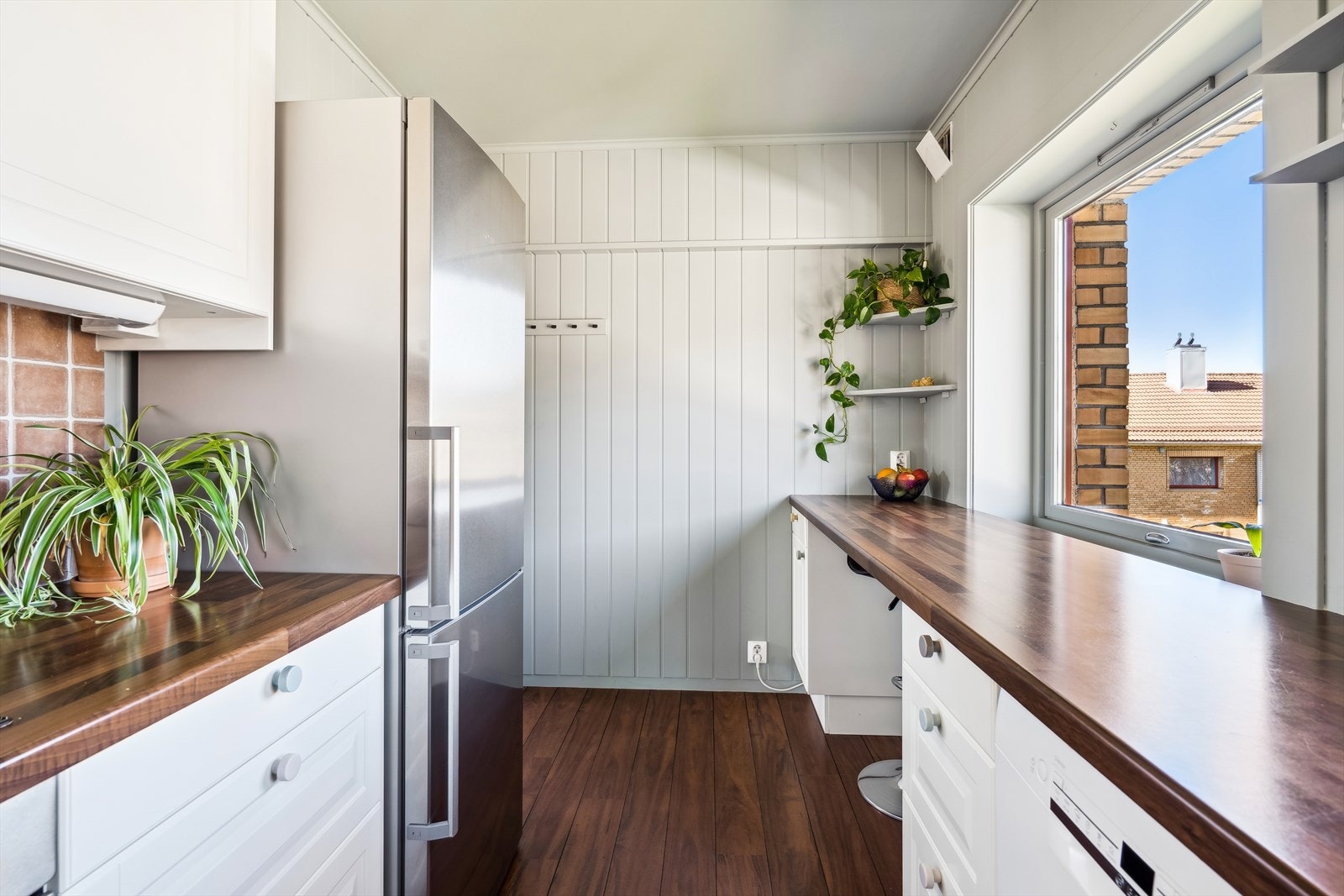 Klassiske, profilerte fronter, fliser over benk, integrert stekeovn og platetopp, samt plass til både oppvaskmaskin og kjøleskap. Galleribilde