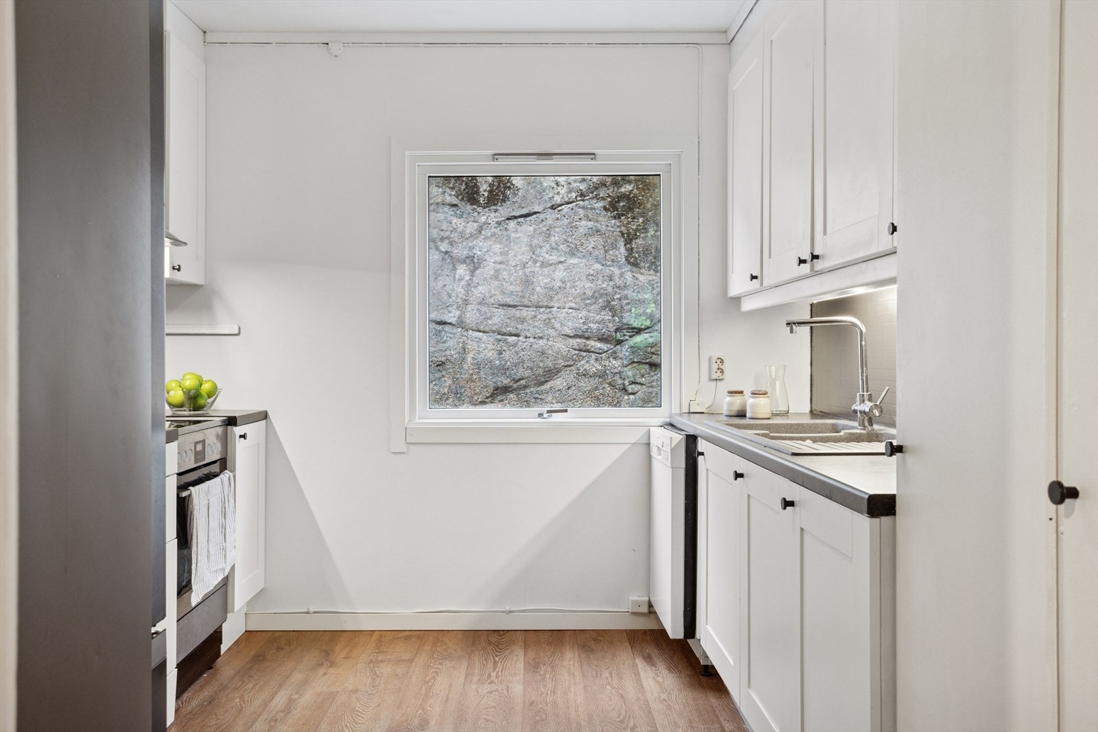 Kjøkkenet har benkeplate av laminat og vask med skyllekum og avrenningsbrett Galleribilde